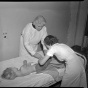 Sister Elizabeth Kenny examining a child and lecturing to visitors.