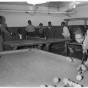 Black and white photograph of people playing table tennis and billiards at the Phyllis Wheatley House, ca. 1940.