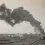 An Oliver Mining Company locomotive hauls ore away from an open pit near Hibbing, Minnesota, 1917. The young city is visible in the background.