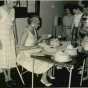 Black and white photograph of a Farm Bureau cake contest, 1960, with Mrs. Milford Peterson (seated) as judge.