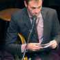 Prairie Home Companion host Chris Thile reads audience greetings during a broadcast at the Fitzgerald Theater in January 2016. Photograph by Wikimedia Commons user Jonathunder.