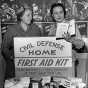 Black and white photograph of women with civil defense home first aid kit display, 1954.