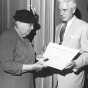 Black and white photograph of Frances Densmore being presented with citation by Harold Dean Carter. 