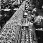 Black and white photograph of Honeywell Round thermostats ready for final checkout and packaging at a factory in Golden Valley, c.1955. 