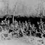 Black and white photograph of a Lumber crew eating outdoors, ca. 1900. Photograph by A.A. Swan.