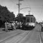 Black and white photograph of the last streetcar to run on France between Forty-Forth Street and Fifty-Forth Street passes the work crew that is about to tear up the track, August 10, 1952.