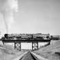 Black and white photograph of a Duluth, Missabe and Iron Range train on railroad bridge west of Two Harbors, ca. 1940.