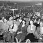 Black and white photograph of a Socialist Workers Party meeting, ca. 1940. Vincent R. Dunne and Grace Carlson sit in the center of the front row.