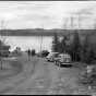 A view of cars, visitors, and Gunflint Lake at Gunflint Lodge. Photograph by Kenneth Melvin Wright, ca. 1950.