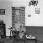 Black and white photograph of Mrs. Thomas Marcum, wife of the post's civilian electrical engineer, seated in her living room in the Round Tower, 1937.