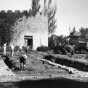 Black and white photograph of an archaeological crew and mechanical equipment near the Round Tower, 1958.