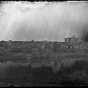 Black and white photograph of St. Anthony looking across Nicollet Island at Winslow House, right, and Universalist Church, left, ca. 1860. 