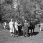 Black and white photograph of owners of a family farm in Maple Plain pose with their animals, October 10, 1955.