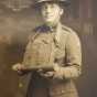 Black and white photograph of YMCA worker Julia Swenson holding a grenade, ca. 1919. Photographer unknown.