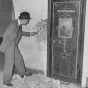 Black and white photograph of Richard Sackett examining the Minnesota Historical Society vault door in the second capitol building prior to its demolition, 1937.