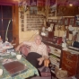 Color image of Dorothy Molter sitting at the kitchen table of the Point Cabin, Isle of Pines, Knife Lake, Boundary Waters Canoe Area, ca. 1970s.