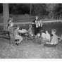 Knutson playing her accordion for a group of children in a park