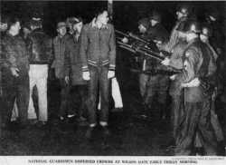 Members of the National Guard confront striking meatpacking plant workers in Albert Lea. Printed in the Minneapolis Morning Tribune, December 12, 1959. Original caption: “National Guardsmen dispersed crowds at Wilson Gate early Friday morning.” Photograph by Charles Brill.