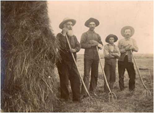 Black and white photograph of Father Anatole Oster (left) with farmers in Clontarf Township, c.1885.