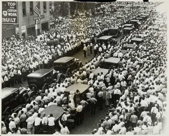 Black and white photograph of the funeral of Henry Ness, a striker killed during the strike, in front of strike headquarters at 215 South Eighth Street, Minneapolis, 1934. 