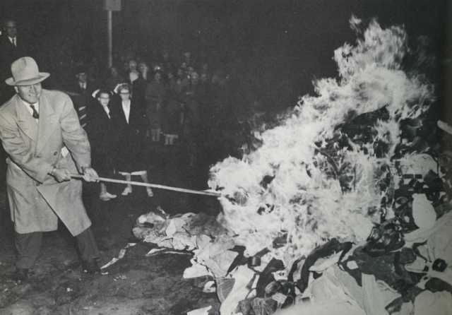 Governor Luther Youngdahl setting fire to restraints at Anoka County Hospital, October 31, 1949. Photograph by Hi Paul. Published in the St. Paul Pioneer Press on November 1, 1949, with the article, “Halloween Fire Heralds Reform—Anoka State Hospital Burns Straitjackets.” Original caption: “A flaming pile of strait jackets, manacles, and straps marked the end of the use of restraints at the Anoka State Hospital Monday night. Gov. Youngdahl, the moving force behind Minnesota’s mental health program, is shown