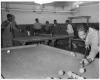 Black and white photograph of people playing table tennis and billiards at the Phyllis Wheatley House, ca. 1940.