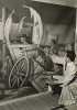 Black and white photograph of artist John Socha at work on a Works Progress Administration mural at the New Ulm High School, 1941. 