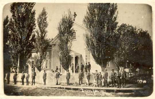 Black and white photograph of a row of people wraped around the front of Singer's Hall, 1870s or 1880s.