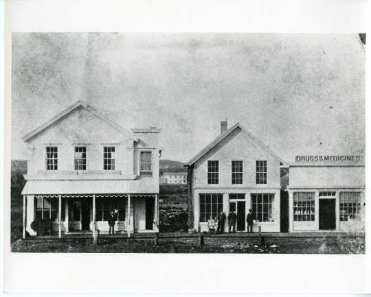 Black and white photograph of Van Campen store and Scofield's drug store, 1883. 
