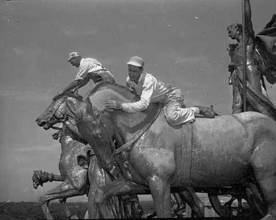 Black and white photograph of workers removing the gold leaf on the Quadriga at the Minnesota State Capitol, St. Paul, 1949.