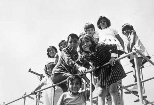 Black and white photograph of Mexican American migrant farm-worker children playing, ca. 1960. 