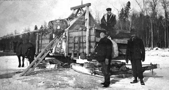 Photograph of Frank Higgins (at left) with two unidentified men near a water wagon c.1920.