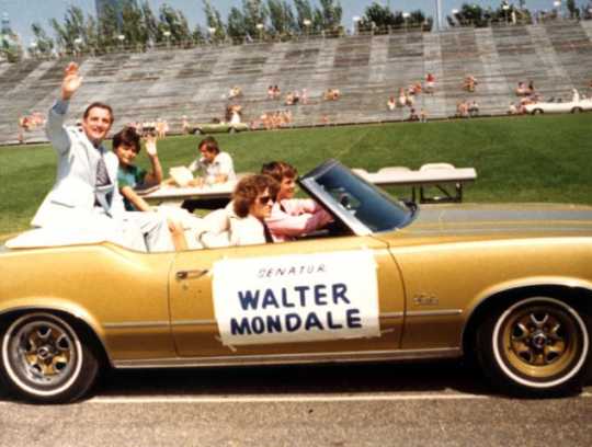 Senator Walter Mondale waves from the back of a car in the Minneapolis Aquatennial Parade, 1972
